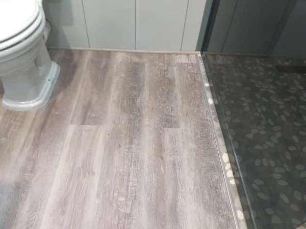 SPC Vinyl floor in bathroom, minimalist quarter round, no skirting